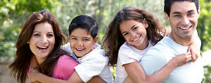 Happy family piggybacking in a park.